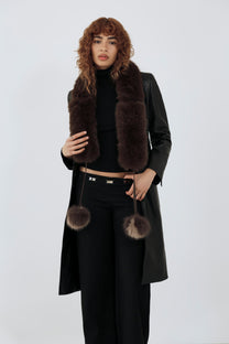 Model wearing an all black outfit and a brown fur scarf against a plain background
