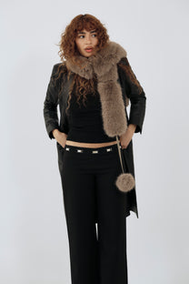 model wearing an all black outfit with a taupe fur scarf against a plain background