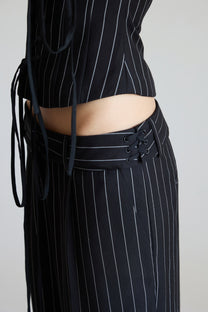 Black pinstripe outfit with a pinstripe top and matching pinstripe pants on a plain background